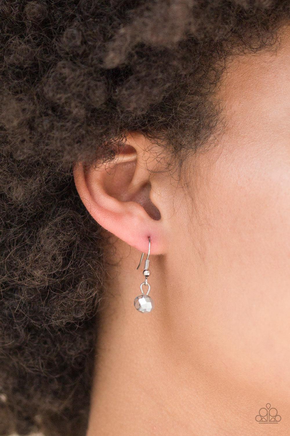 Paparazzi Accessories Socialite of the Season - Silver Splashed in metallic shimmer, a smoky crystal-like bead swings from the bottom of a lengthened silver chain, giving way to a shimmering silver tassel for a glamorous finish. Features an adjustable cla