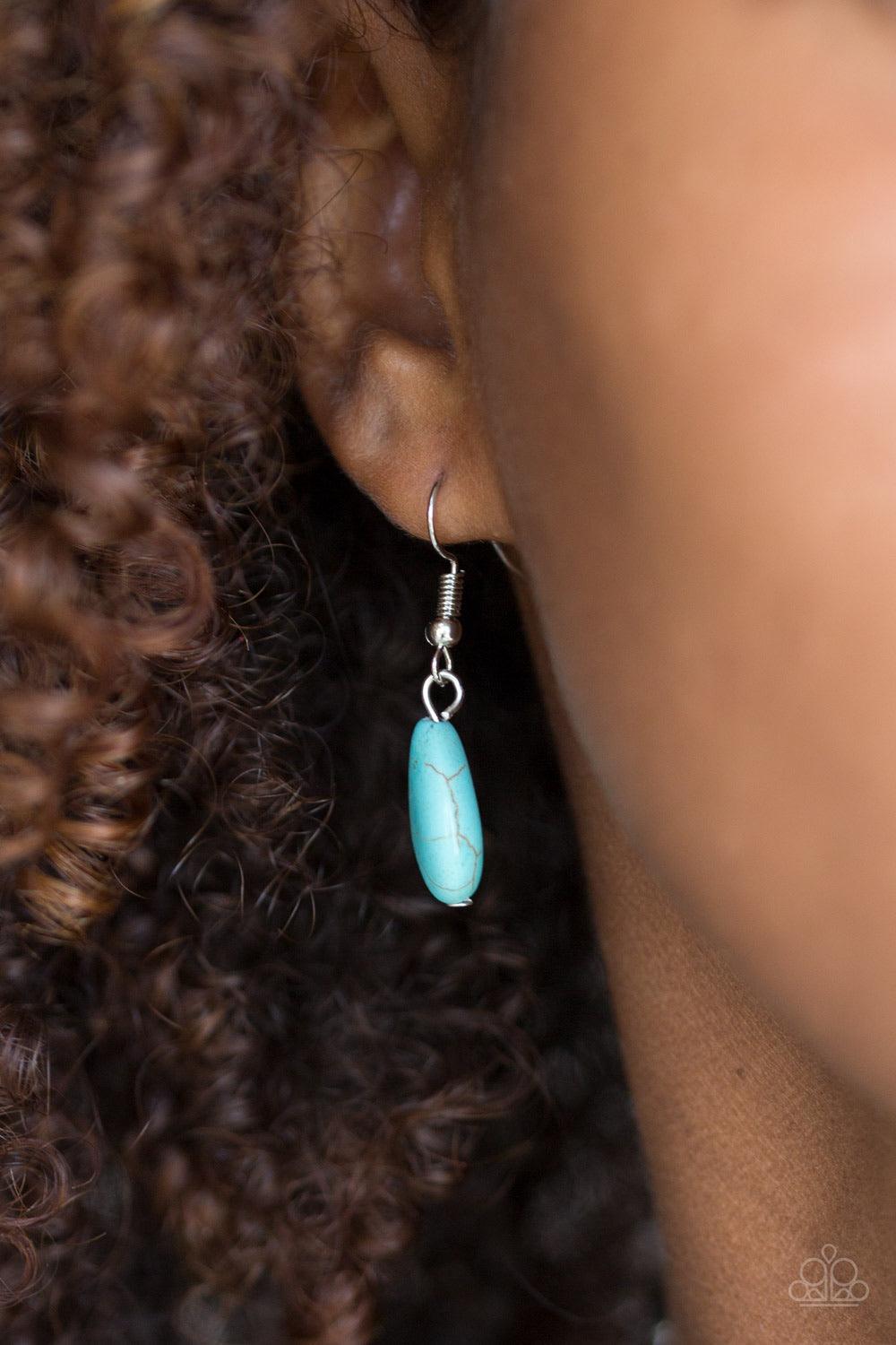 Paparazzi Accessories Very Venturous - Blue Embossed in floral and tribal inspired patterns, a shimmery silver crescent shaped frame swings below the collar in a fierce fashion. Chiseled into a tranquil teardrop, a refreshing turquoise stone is pressed in
