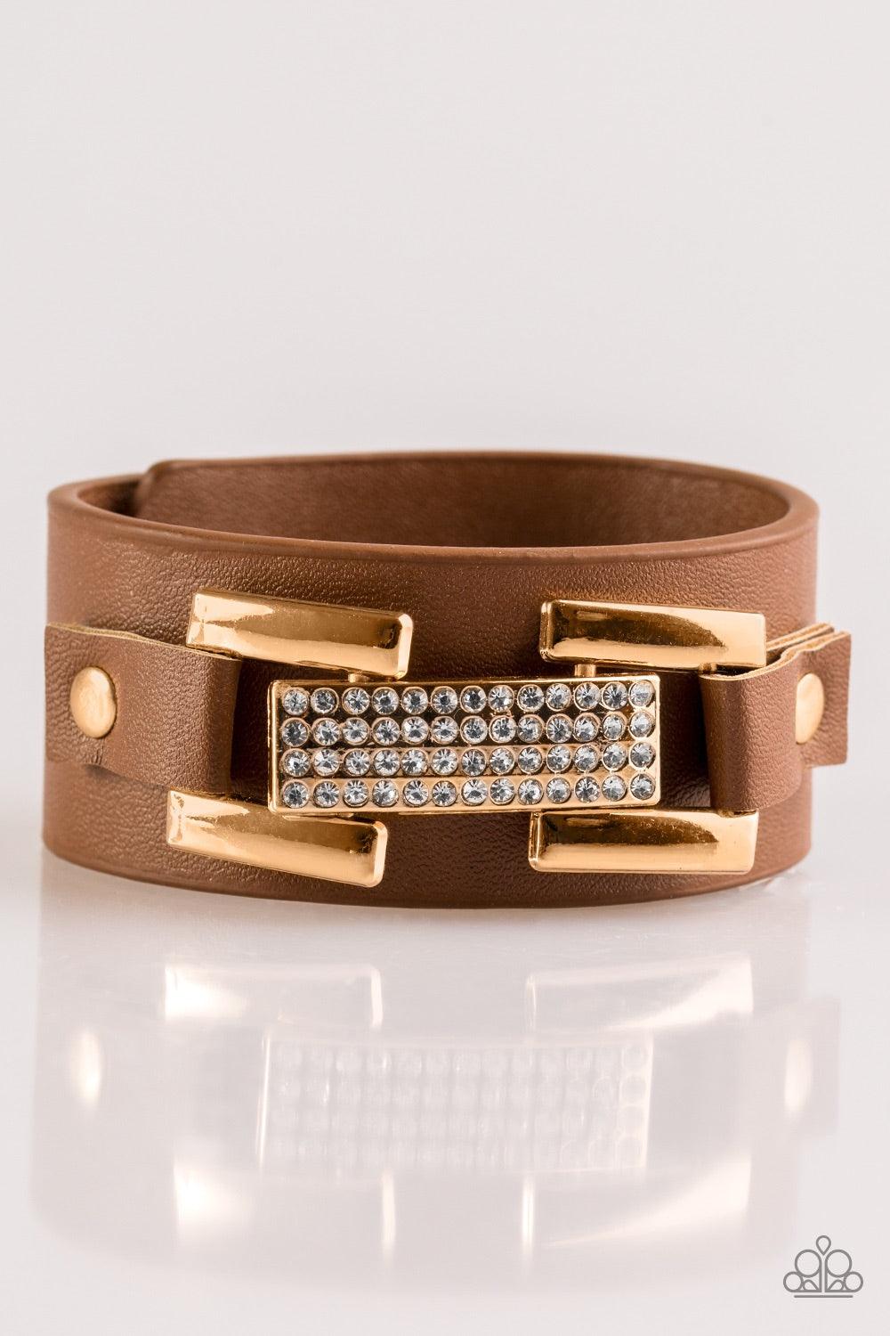 Paparazzi Accessories Going Platinum - Brown Encrusted in glittery white rhinestones, a glistening gold frame is studded in place across the front of a brown leather band for a glamorous look. Features an adjustable snap closure. Jewelry
