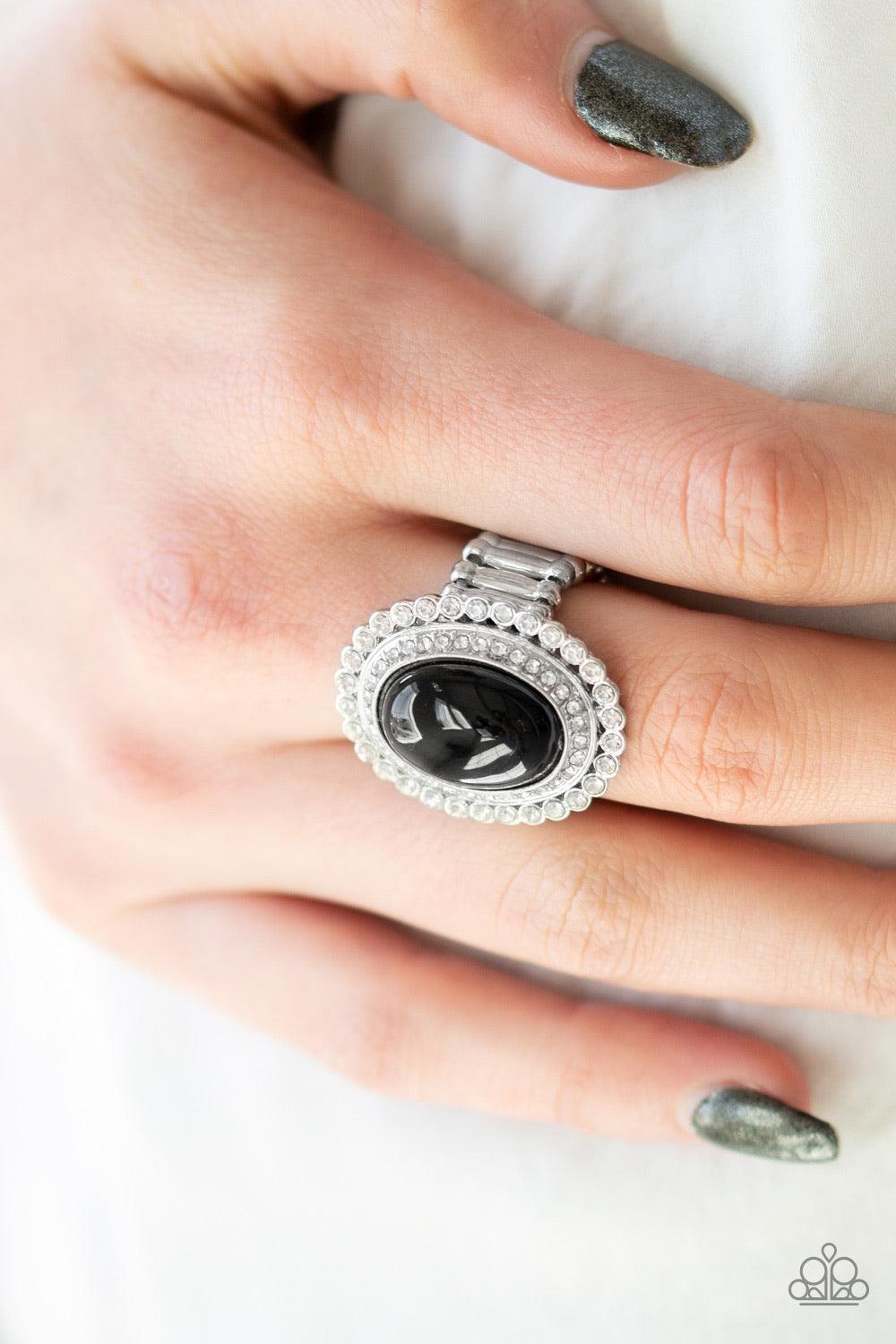 Paparazzi Accessories Opulently Olympian - Black A shiny black bead adorns the center of stacked silver frames encrusted in glassy white rhinestones for a dramatically refined look. Features a stretchy band for a flexible fit. Jewelry