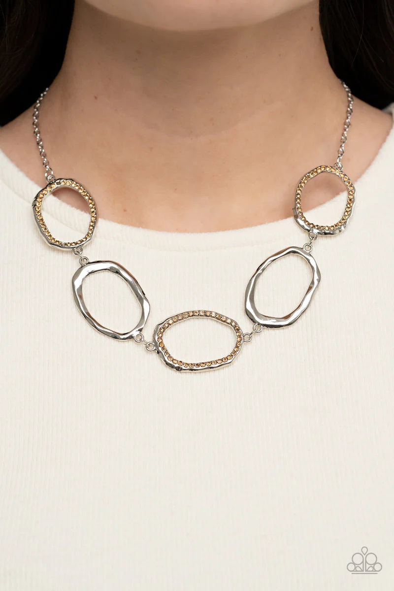 Paparazzi Accessories Grit Go-Getter - Brown A row of dazzling light topaz rhinestones makes its way around a delicately hammered imperfect circular frame. The airy frames alternately link end to end with similar shiny silver frames creating a glitzy fash