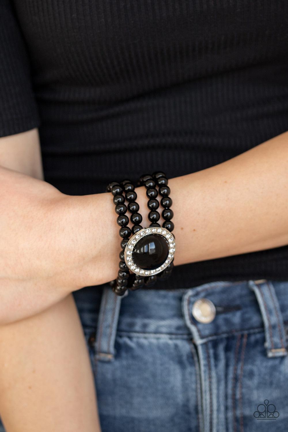 Paparazzi Accessories Top Tier Twinkle - Black Threaded along stretchy bands, row after row of black beads are held in place by an exaggerated black beaded frame encrusted in glassy white rhinestones for a refined finish. Sold as one individual bracelet.
