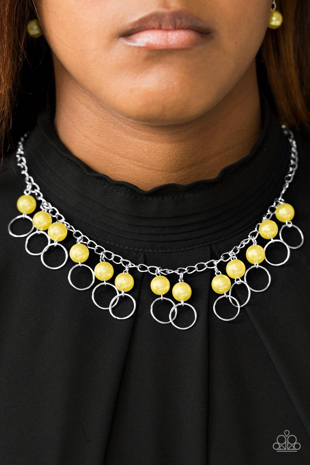 Paparazzi Accessories Run The Show - Yellow Classic yellow pearls trickle from the bottom of a glistening silver chain. Shimmery silver hoops cascade from the pearls, creating a flirty fringe below the collar. Features an adjustable clasp closure. Jewelry
