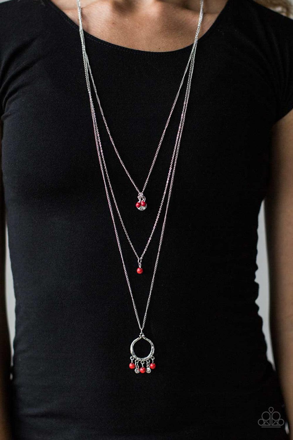 Paparazzi Accessories Texas Tempest - Red Dainty red and brown stone beading trickles from three shimmery silver chains. A hammered silver disc hangs from the uppermost chain as a large silver pendant swings from the bottom in a wanderlust fashion. Featur