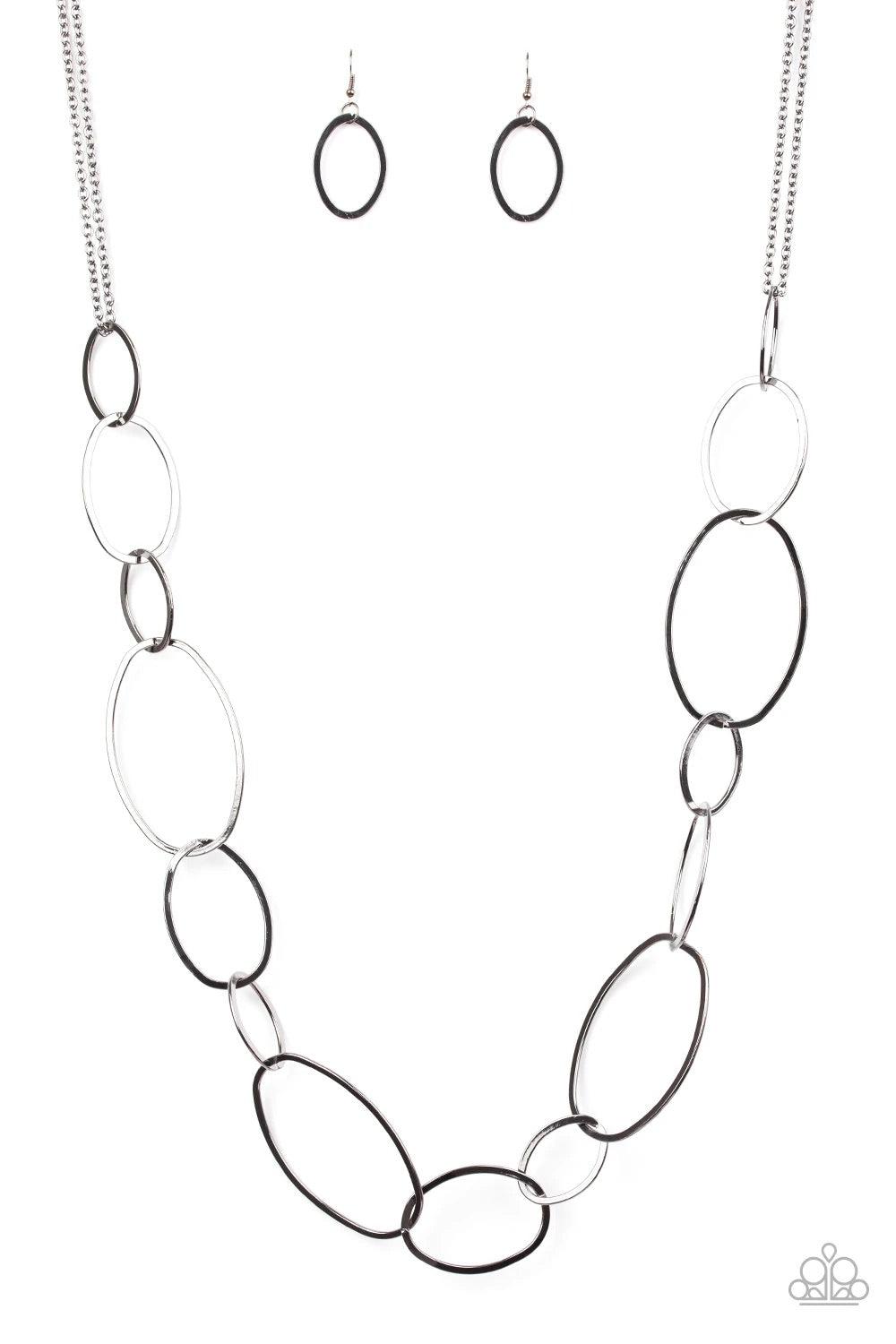 Paparazzi Accessories City Circuit - Black Swinging from doubled gunmetal chains, oversized asymmetrical hoops dramatically link across the chest for a refined industrial look. Features an adjustable clasp closure. Jewelry