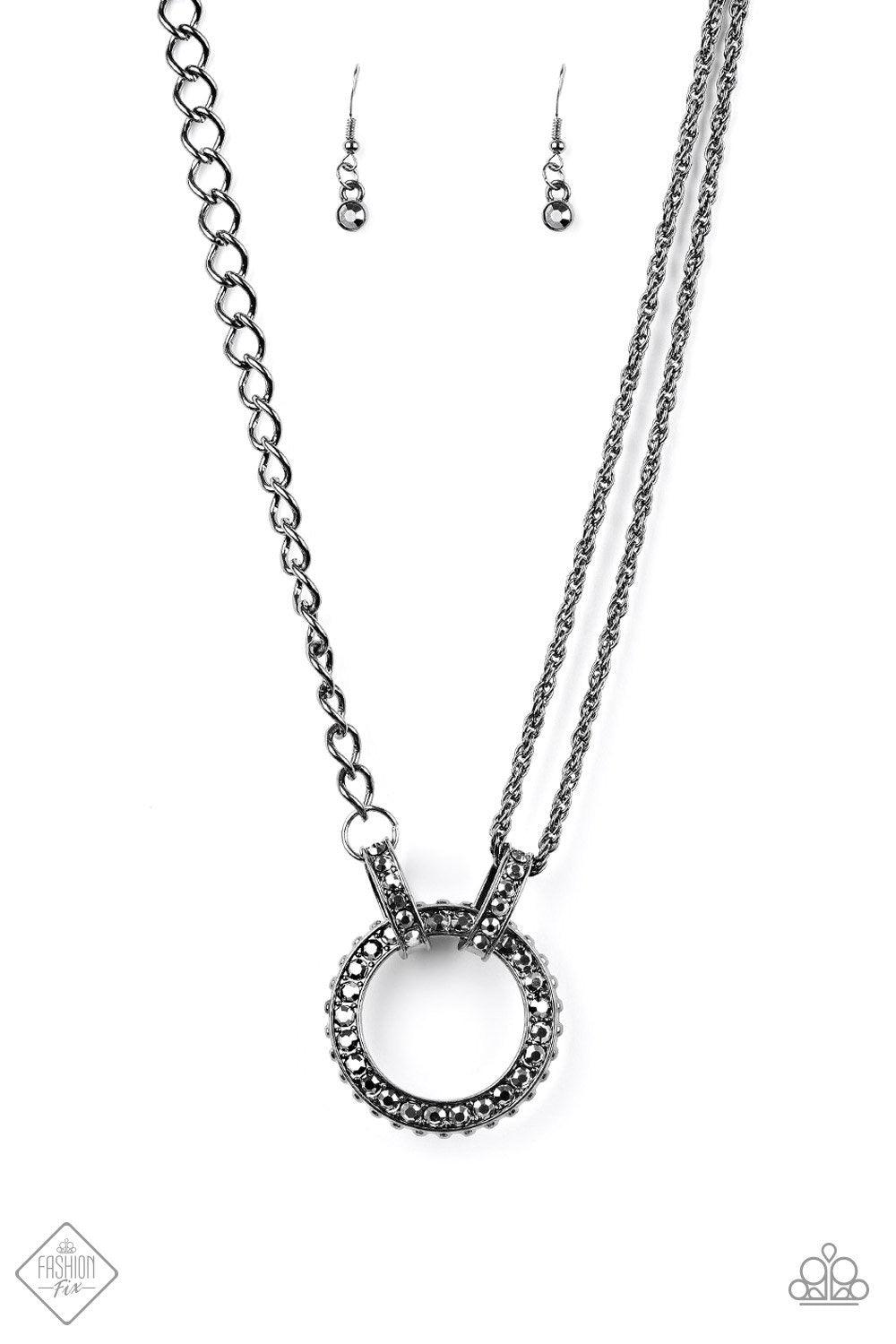 Paparazzi Accessories Razzle Dazzle - Black Featuring mismatched gunmetal black chains, a studded black pendant is encrusted in glittery black rhinestones and hangs below the collar for a dramatic industrial look. Features an adjustable clasp closure. Jew