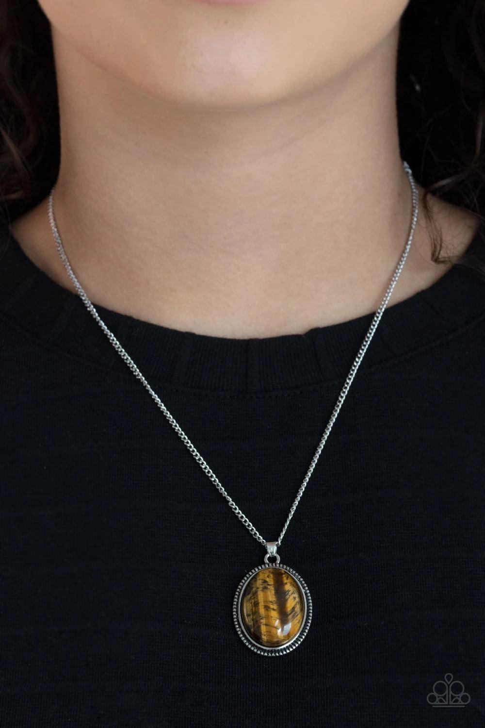Paparazzi Accessories Tranquil Talisman - Brown An oval tiger's eye stone is pressed into the center of a studded silver frame, creating a tranquil pendant below the collar. Features an adjustable clasp closure. Sold as one individual necklace. Includes o