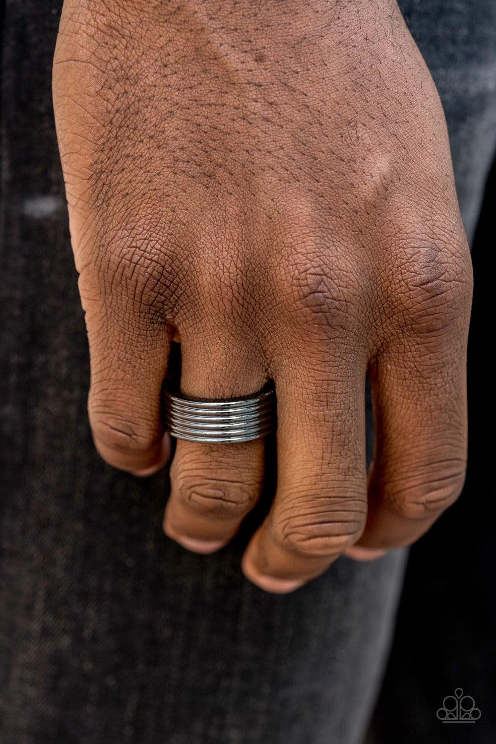Paparazzi Accessories A Mans Man - Black A thick gunmetal band is lined in stacked linear textures for a sleek metro look. Features a stretchy band for a flexible fit. Jewelry