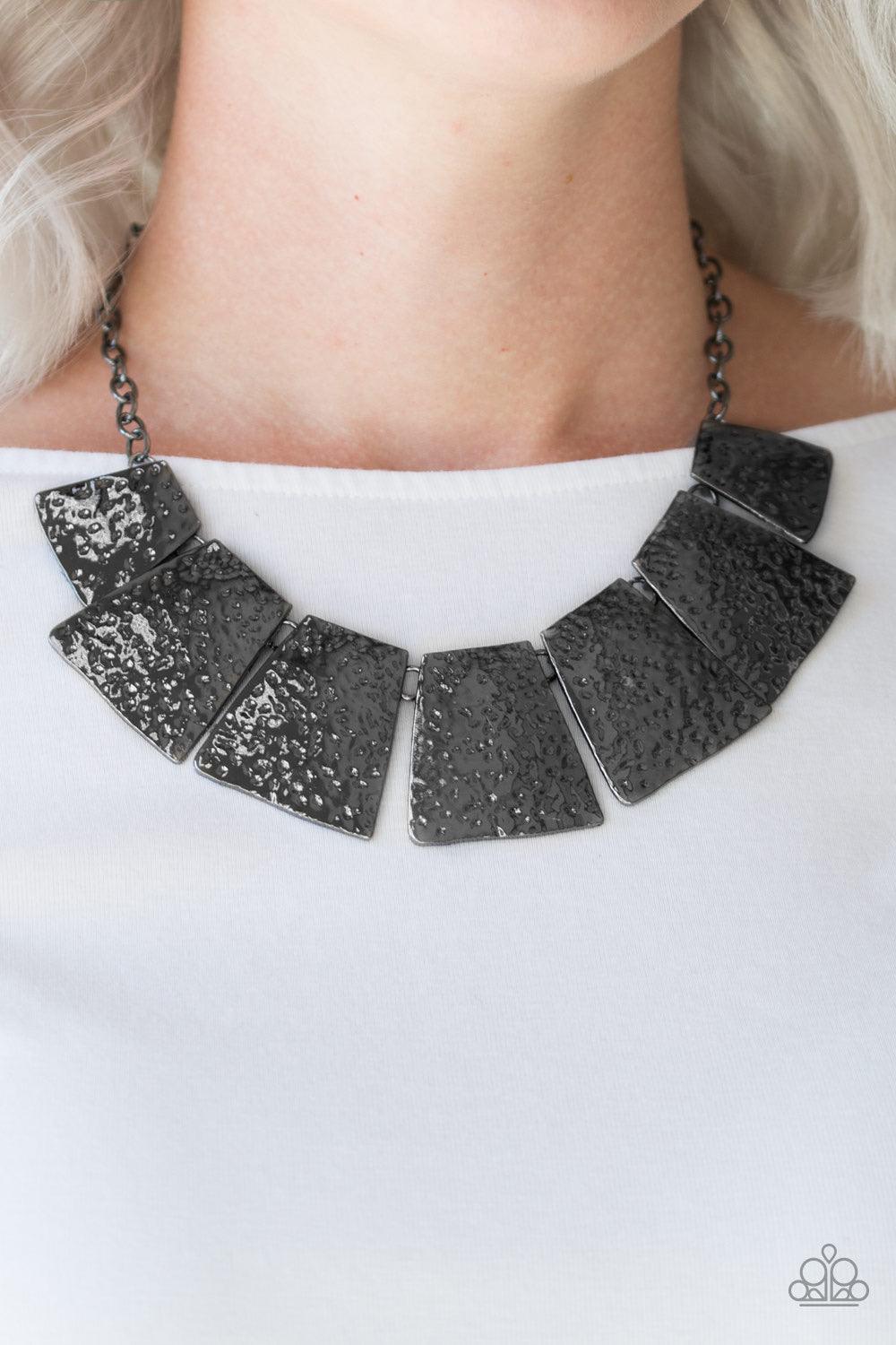 Paparazzi Accessories Here Comes The Huntress - Black Featuring flared edges, delicately hammered gunmetal plates link below the collar for a fierce look. Features an adjustable clasp closure. Sold as one individual necklace. Includes one pair of matching
