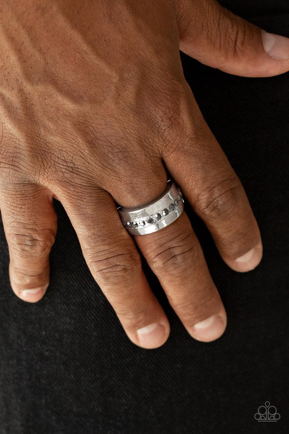 Paparazzi Accessories Reigning Champ - Silver A single row of glassy hematite rhinestones is encrusted along the center of a thick silver band. Features a stretchy band for a flexible fit. Jewelry