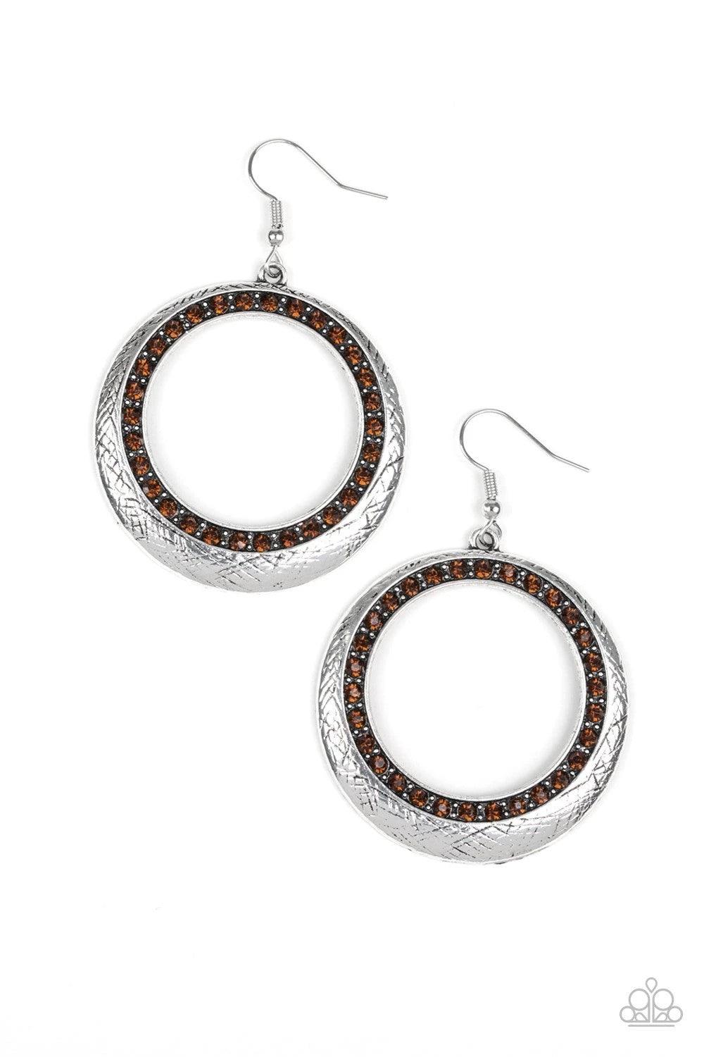 Paparazzi Accessories Go-Go Glow - Brown Delicately scratched in antiqued shimmer, a glistening silver hoop is encrusted in a ring of glittery topaz rhinestones for a refined look. Earring attaches to a standard fishhook fitting. Sold as one pair of earri