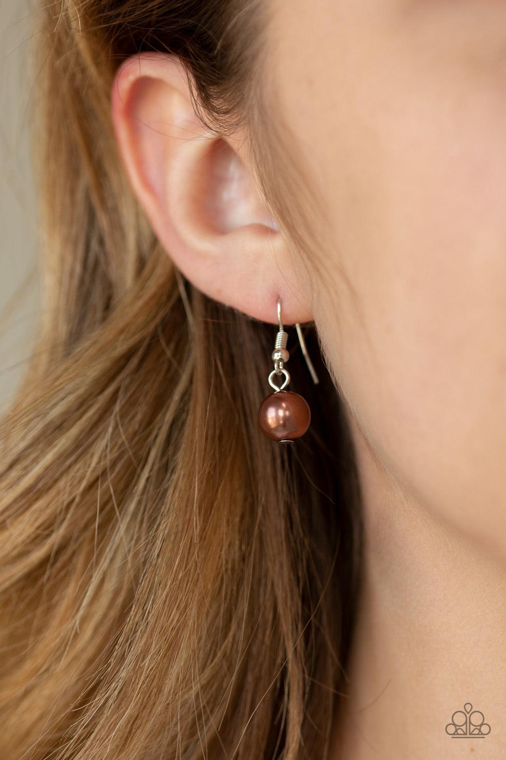 Paparazzi Accessories SoHo Socialite - Brown Threaded along an invisible wire, classic brown pearls give way to an alternating collection of oversized brown pearls and white rhinestone encrusted rings below the collar for a timeless sparkle. Features an a