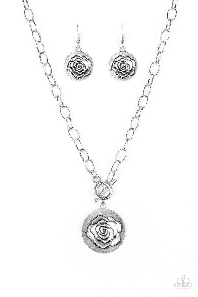 Paparazzi Accessories Beautifully Belle - Silver Embossed in a whimsical rosebud pattern, a shimmery silver frame swings below the collar for a casual look. Features a toggle closure. Sold as one individual necklace. Includes one pair of matching earrings