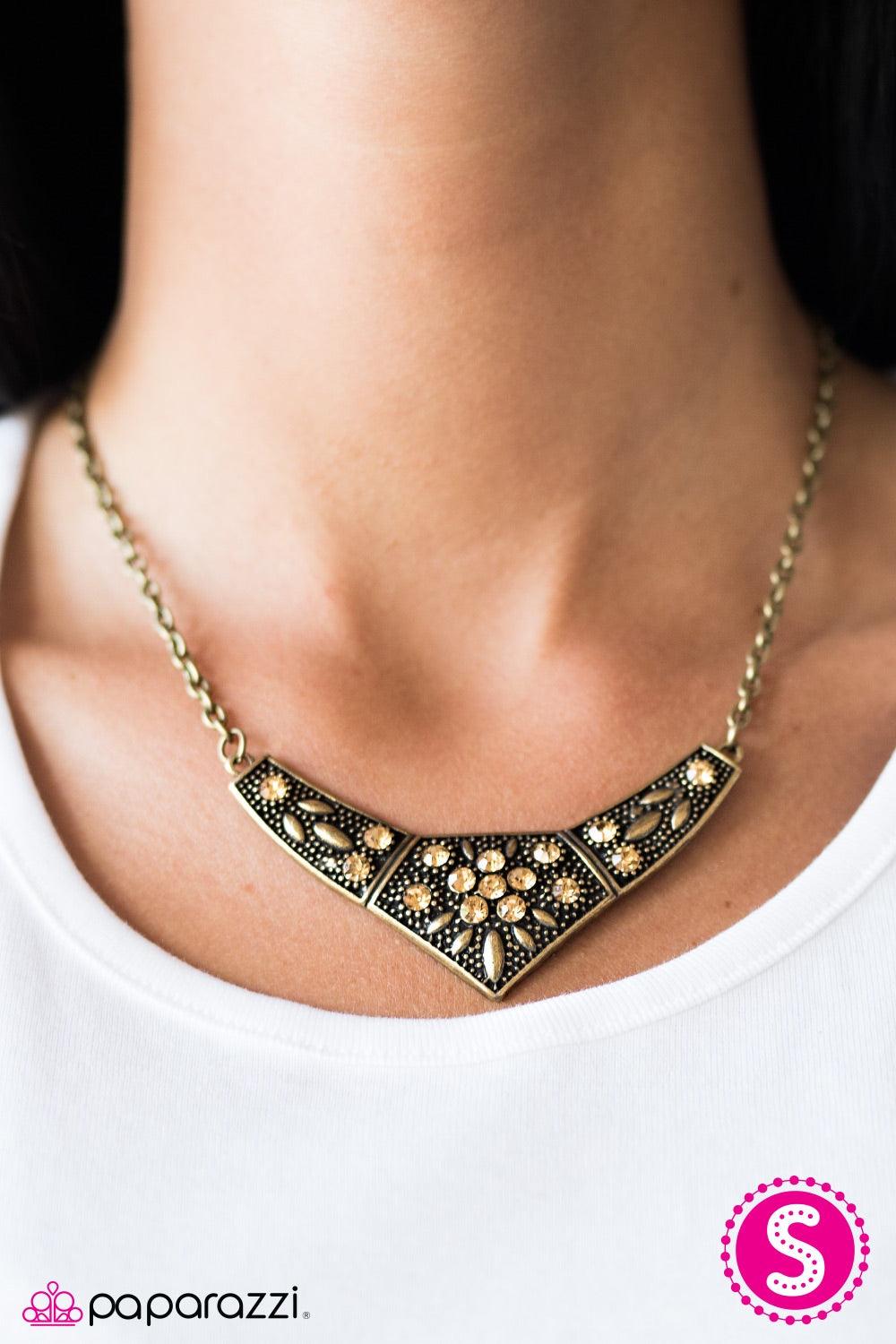 Paparazzi Accessories Born to Shimmer - Brass Embossed in leafy patterns, a bold brass frame falls below the collar in dramatic fashion. Golden topaz rhinestones are sprinkled across the frame, creating a feminine floral center. Features an adjustable cla