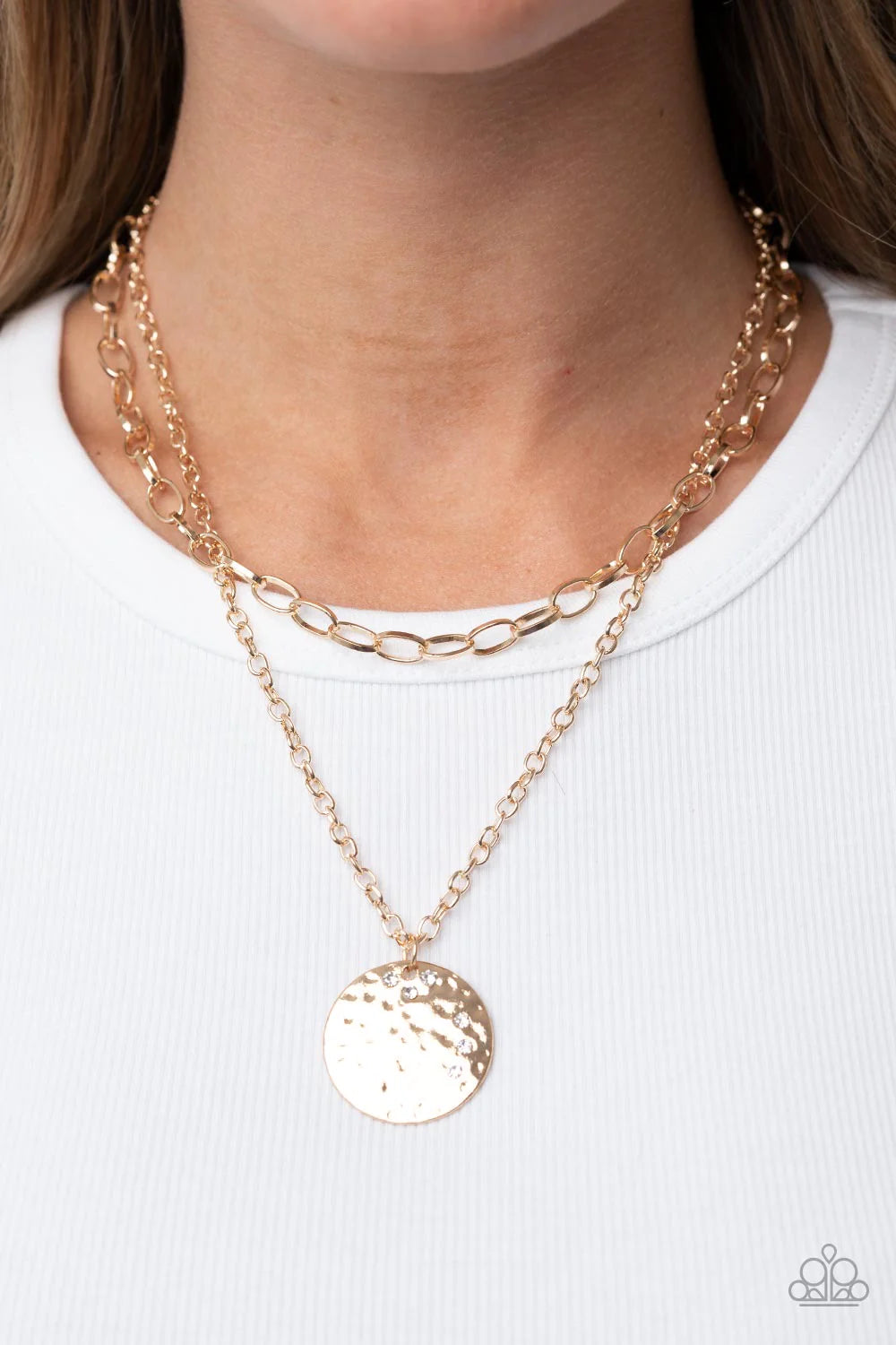 Paparazzi Accessories Highlight of My Life - Gold Sporadically dotted in glittery white rhinestones, an oversized hammered gold disc is suspended from the lowermost of two mismatched gold chains below the collar for a retro look. Features an adjustable cl