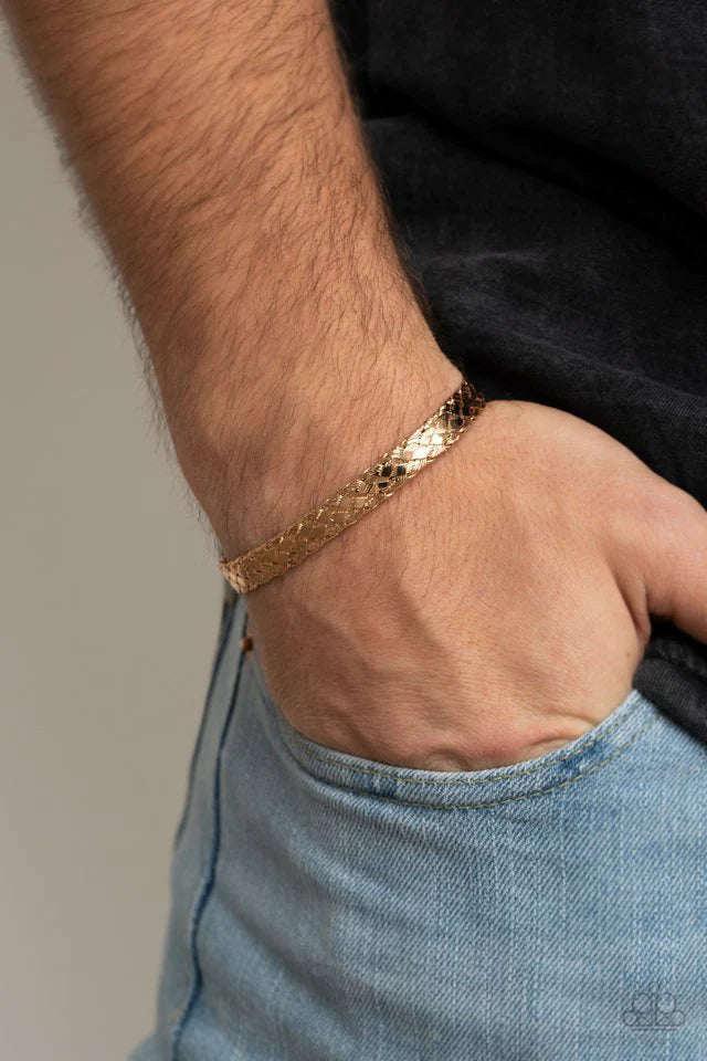 Paparazzi Accessories Cable Couture - Gold Featuring flattened sections, glistening gold wires tightly weave into a dainty cuff for an edgy look around the wrist. Jewelry