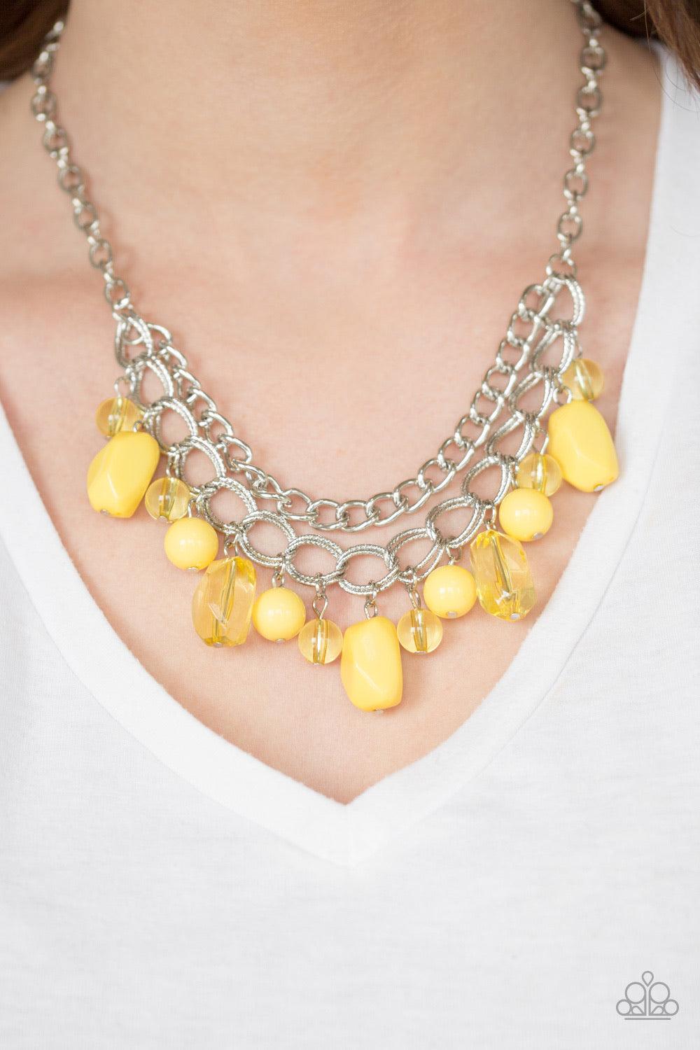 Paparazzi Accessories Brazilian Bay - Yellow Featuring glassy and polished finishes, round and asymmetrical yellow beads trickle from the bottom of a double-linked silver chain. An additional silver chain is layered above the summery beading for a seasona