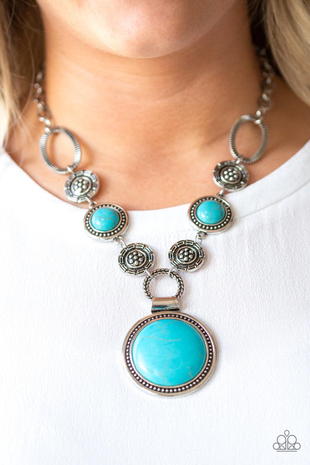 Paparazzi Accessories Sedona Drama ~Blue Featuring floral, textured, and refreshing turquoise stone accents, a collection of unique silver frames link below the collar for a seasonal flair. A dramatically oversized turquoise stone pendant dangles from the
