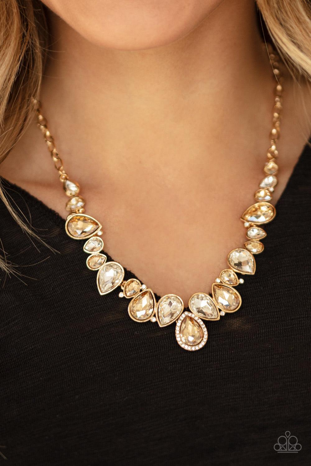 Paparazzi Accessories I Want It All - Gold A sassy combination of golden and white teardrop gems delicately link into a stunning piece below the collar. Dainty white rhinestones are scattered through the piece for unexpected hints of shimmer. Features an