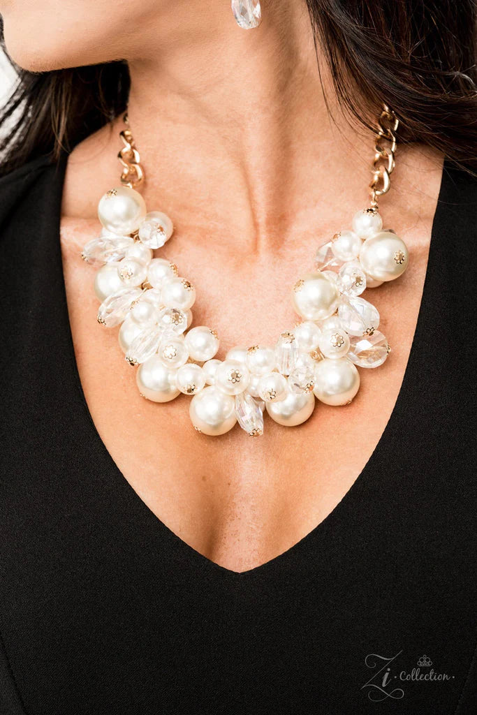 Paparazzi Accessories Captivate An oversized gold chain gives way to an exaggerated cluster of bubbly white pearls, glassy crystal-like beads, and prismatic crystal teardrops. The dramatic fringe converges below the collar, creating a breathtaking stateme