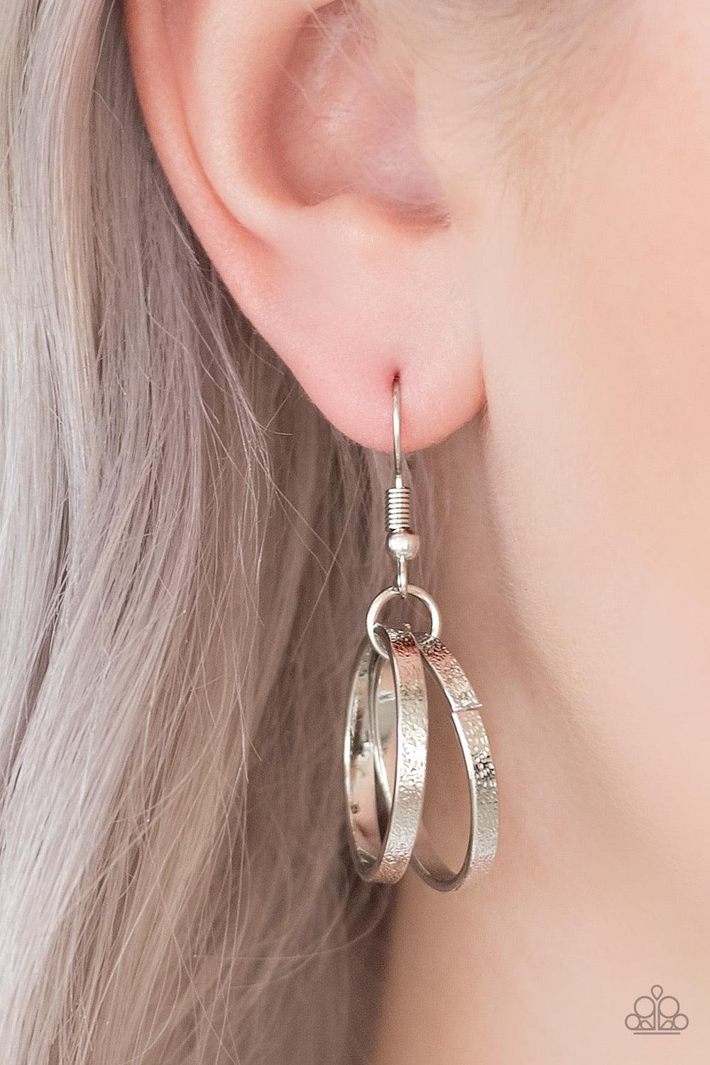 Paparazzi Accessories Statement Made - Silver Etched in light-catching shimmer, glistening silver rings link below the collar, connecting into a bold clustered fringe for a fierce industrial look. Features an adjustable clasp closure. Sold as one individu