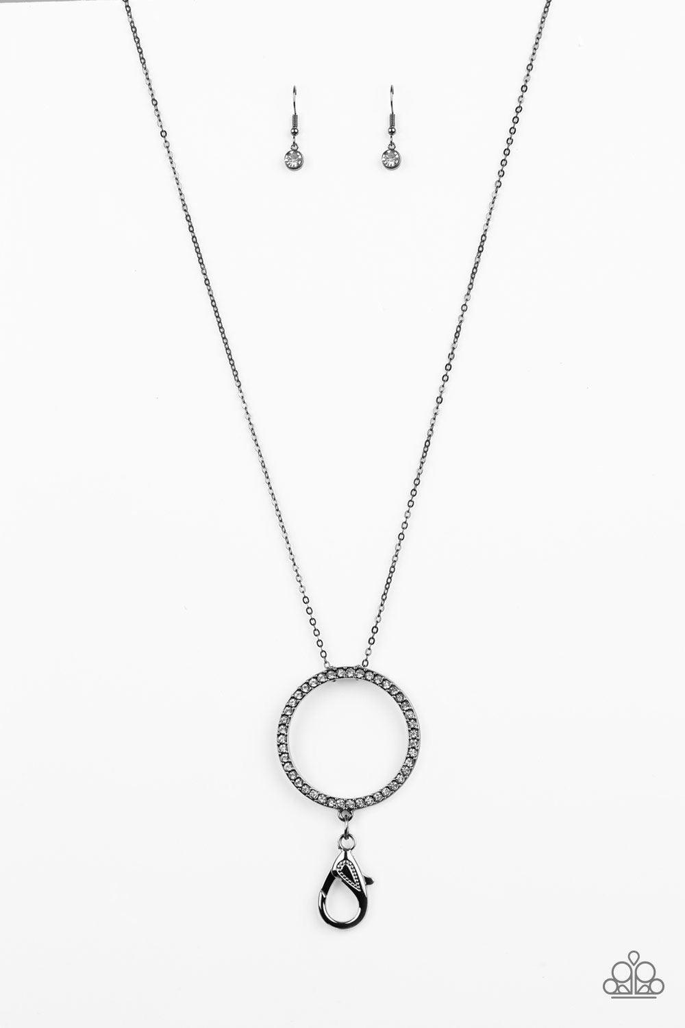Paparazzi Accessories Center of Attention Lanyard - Black Encrusted in glittery white rhinestones, a dramatic gunmetal hoop swings from the bottom of a lengthened gunmetal chain for a refined look. A lobster clasp hangs from the bottom of the design to al