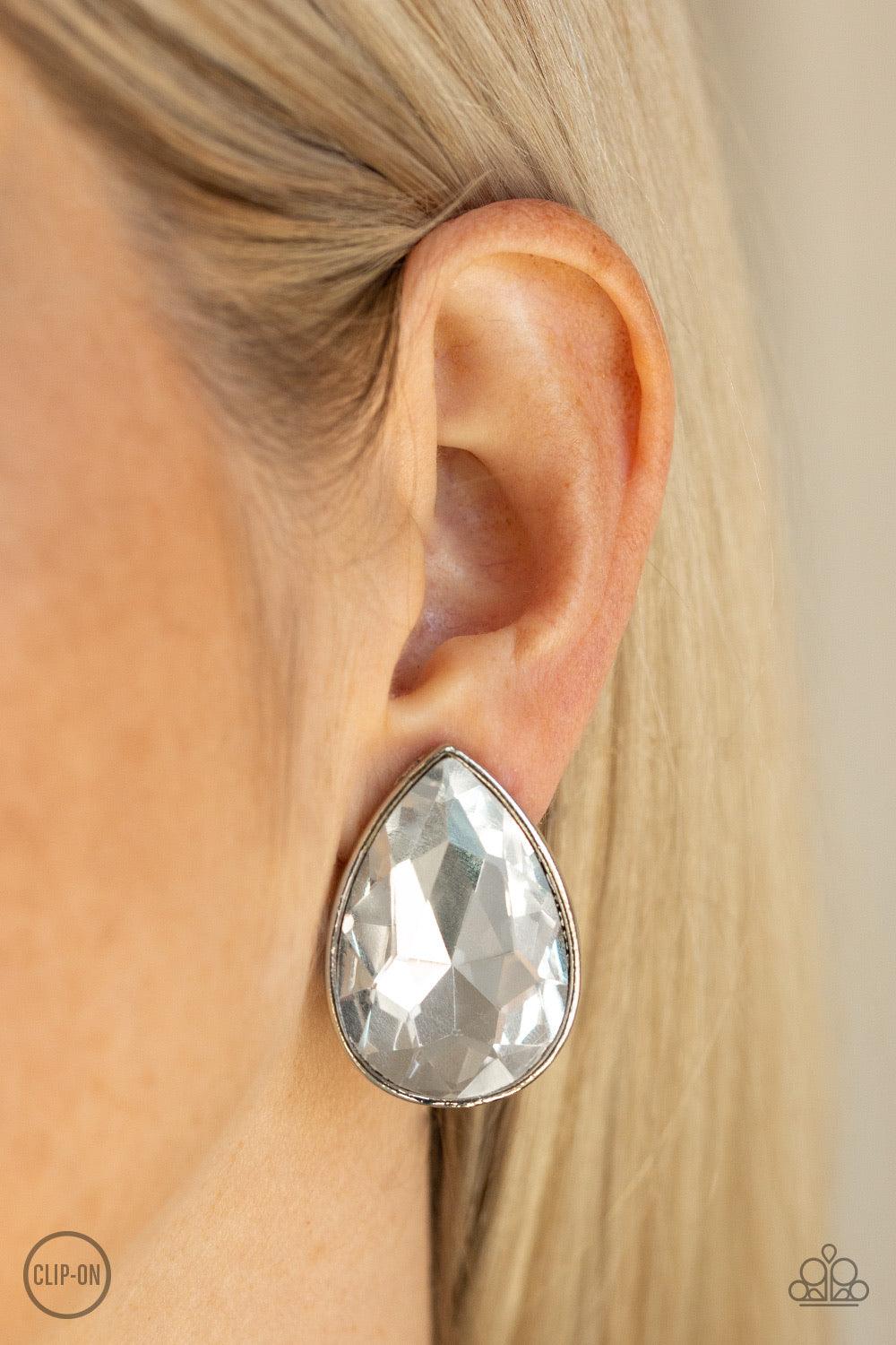 Paparazzi Accessories Dance On HEIR - White *Clip-On A dramatically oversized white teardrop rhinestone is pressed into a sleek silver frame for a show-stopping glam. Earring attaches to a standard clip-on fitting. Jewelry