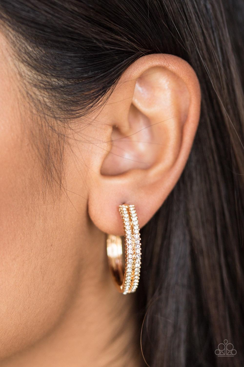 Paparazzi Accessories Slay Your Way ~Gold Two rows of glittery white rhinestones are encrusted along the top half of a glistening gold hoop for a glamorous look. Earring attaches to a standard post fitting. Hoop measures 1" in diameter.