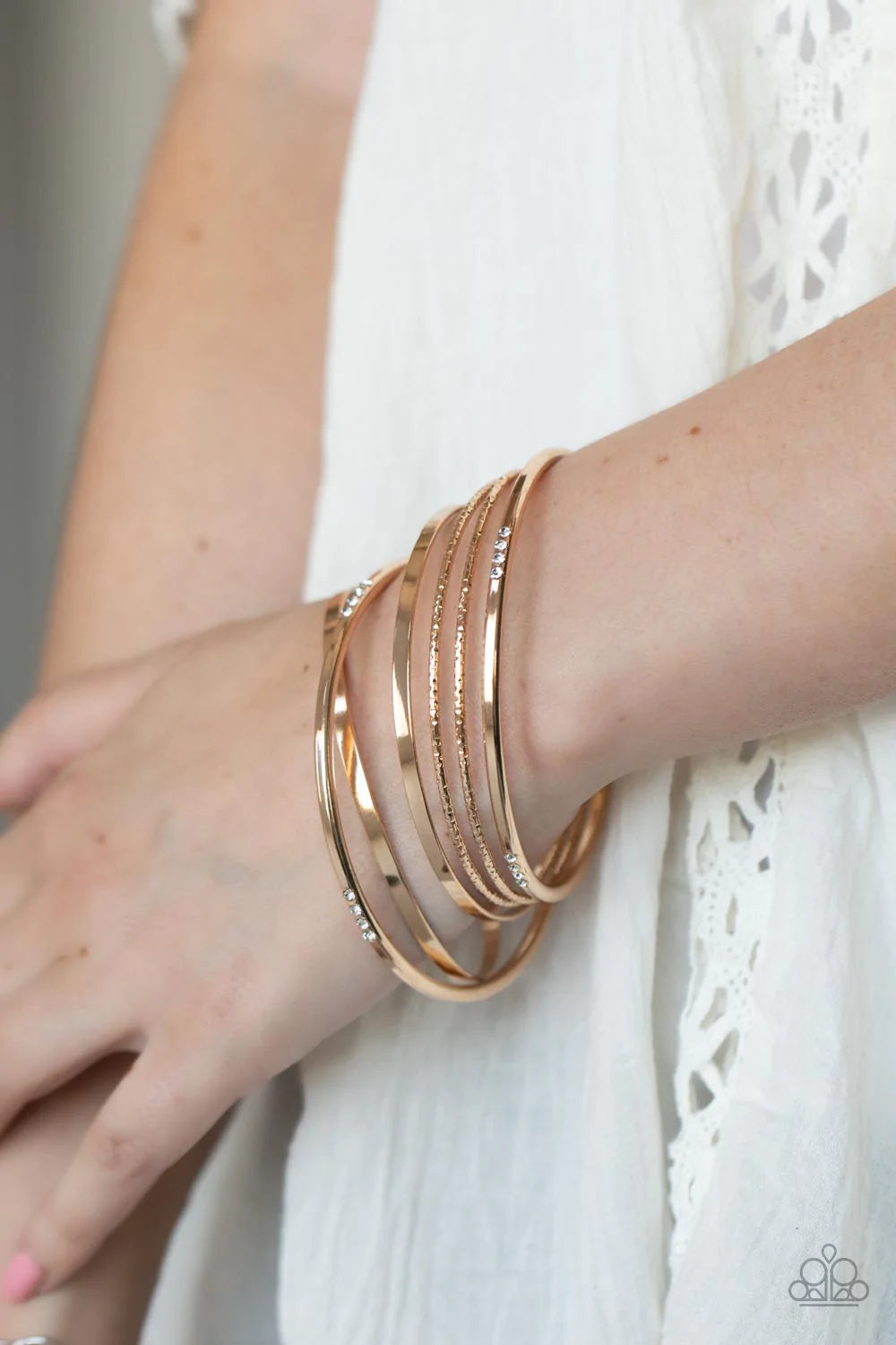 Paparazzi Accessories Lock, STACK, and Barrel - Gold Encrusted in sections of glittery white rhinestones, a mismatched collection of sparkly, smooth, and textured gold bangles stylishly stack up the wrist for a standout look. Sold as one bracelet. Jewelry