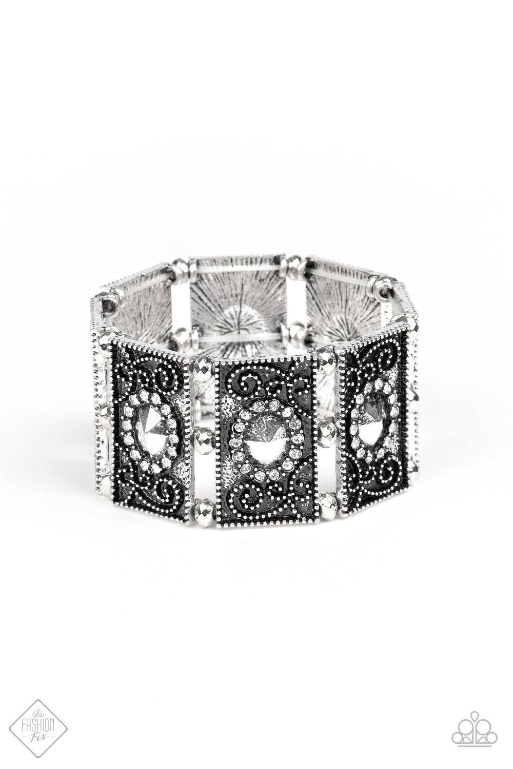 Paparazzi Accessories Tycoon Texture - Silver Featuring faceted silver beaded and white rhinestone encrusted centers, rectangular filigree filled silver frames are threaded along a stretchy band around the wrist for a vintage inspired look. Jewelry