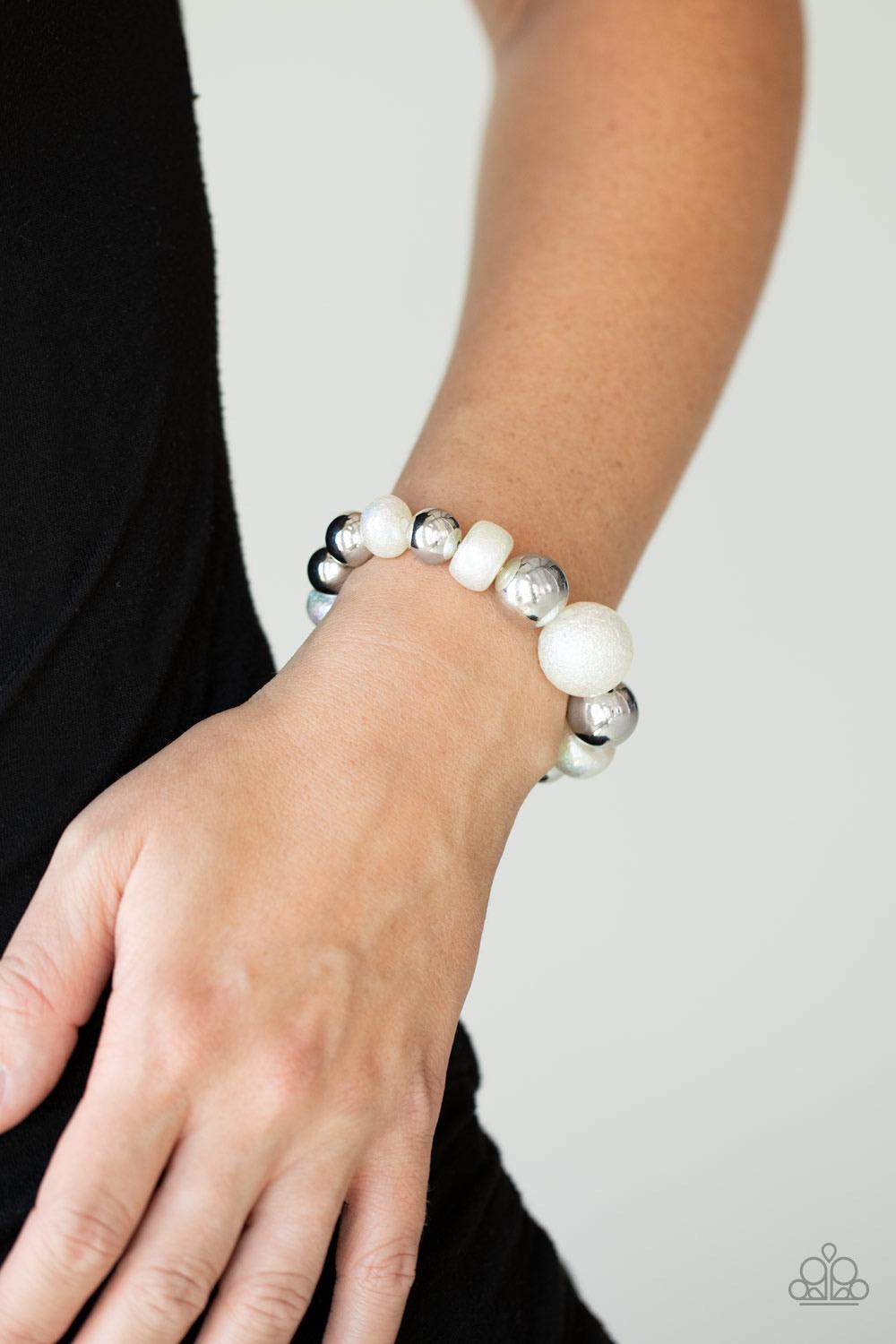 Paparazzi Accessories Starstruck Shimmer - White Brushed in a stellar iridescence, hammered pearly beads and classic silver beads gradually increase in size as they slide along a stretchy band around the wrist for a glamorous look. Sold as one individual