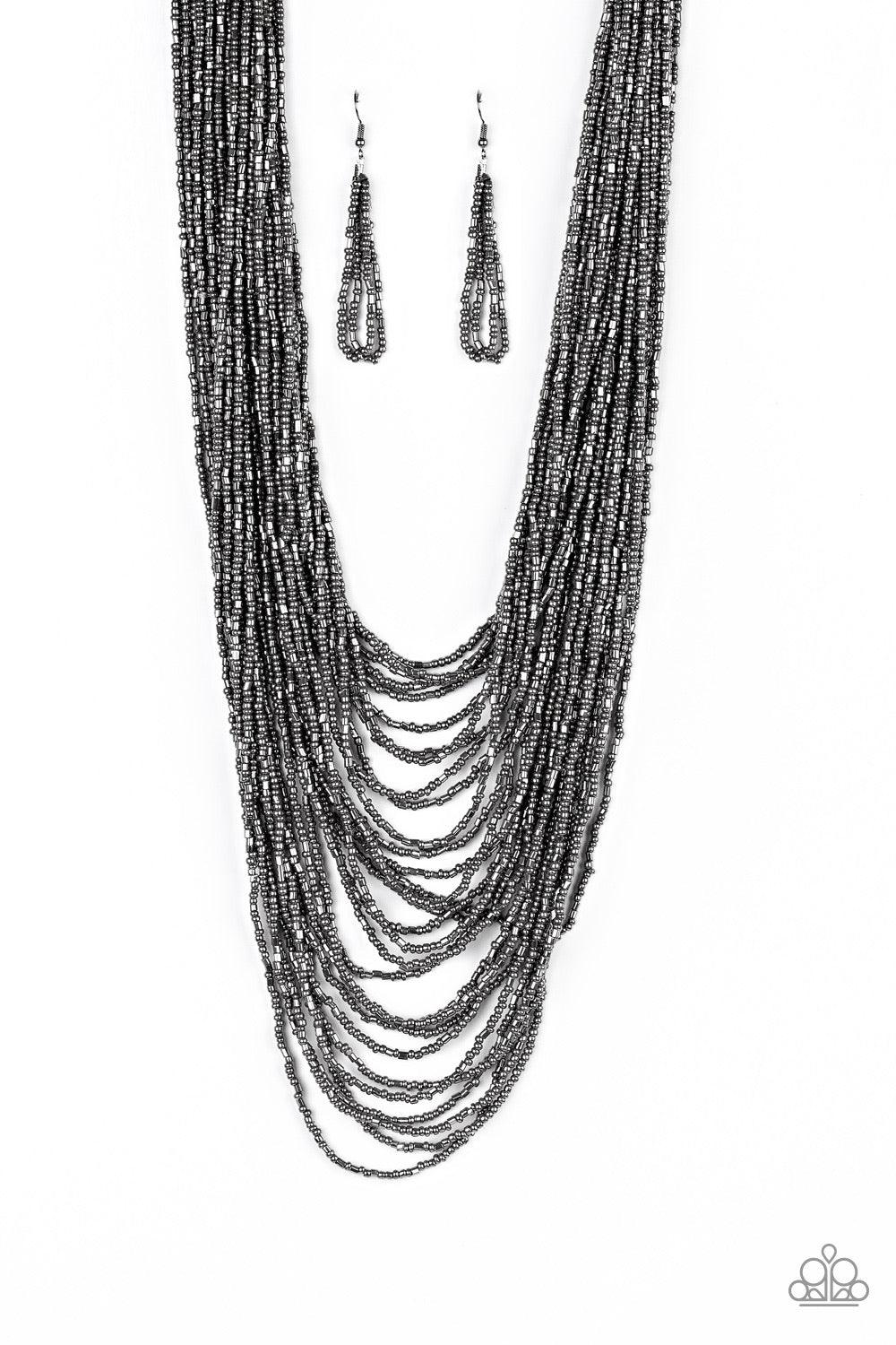 Paparazzi Accessories Dauntless Dazzle - Black Brushed in an icy metallic shimmer, countless strands of gunmetal seed beads drape across the chest in a bold fashion. Featuring a collision of shapes and shimmer, the glittery strands connect to two large gu
