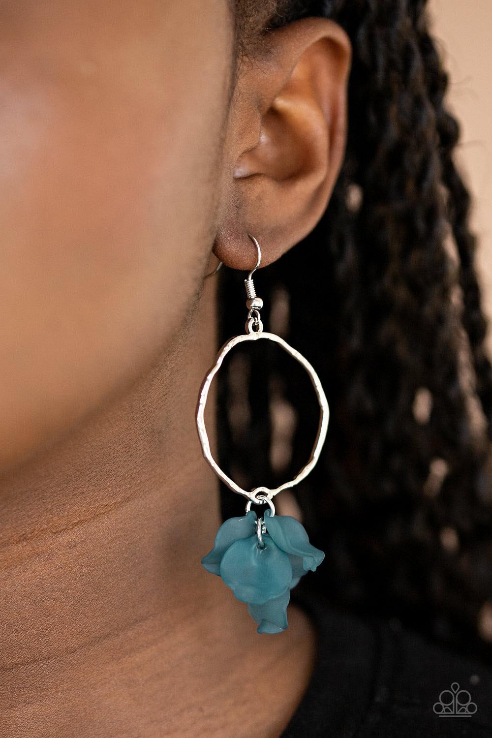 Paparazzi Accessories Petals On The Floor - Blue A cluster of blue acrylic petals delicately swings from the bottom of a hammered asymmetrical hoop, creating a colorful lure. Earring attaches to a standard fishhook fitting. Sold as one pair of earrings. J