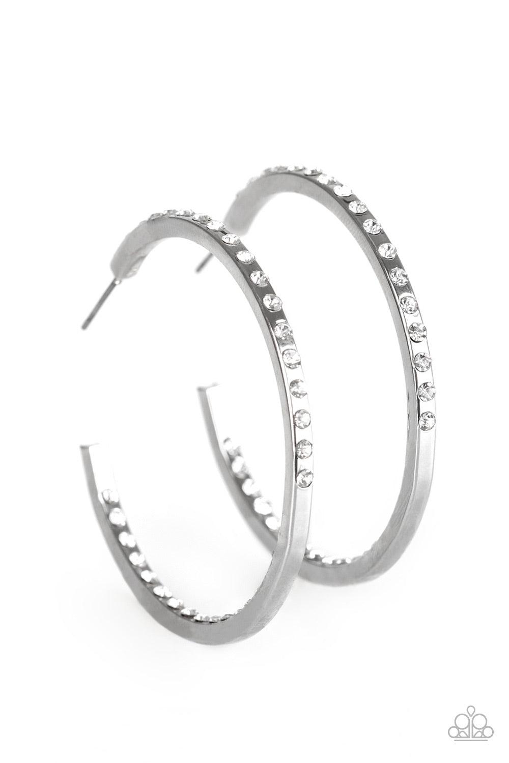 Paparazzi Accessories Comin’ Into Money - White The front half and inner backside of a sleek silver hoop is encrusted in glassy white rhinestones, easily catching and reflecting the light for an extra dash of shimmer. Earring attaches to a standard post f