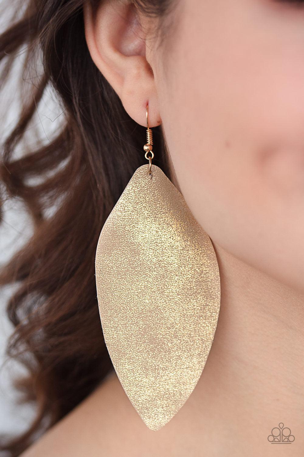 Paparazzi Accessories Serenely Smattered - Gold Dusted in a golden shimmer, an asymmetrical piece of leather swings from the ear in a statement-making fashion. Earring attaches to a standard fishhook fitting. Jewelry