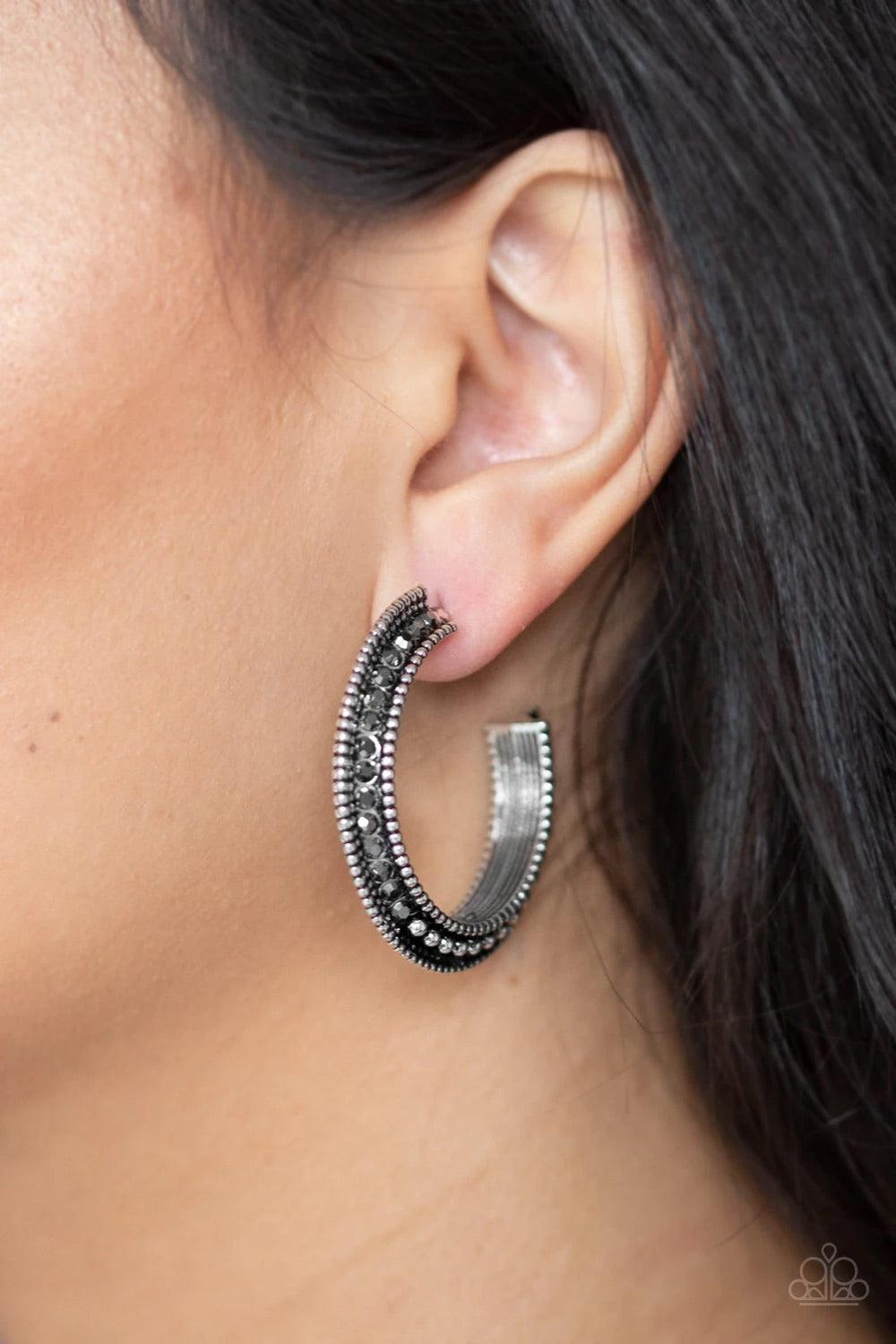 Paparazzi Accessories Retro Reverberation - Silver The top half of a bold silver frame is encrusted in hematite rhinestones, giving way to glistening silver studs for an edgy finish. Earring attaches to a standard post fitting. Hoop measures approximately