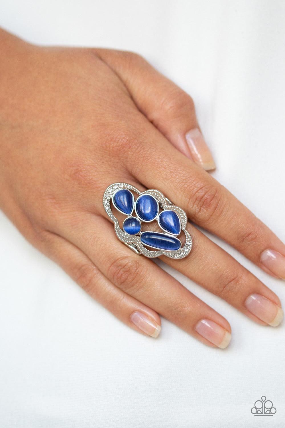 Paparazzi Accessories Cherished Collection - Blue Dotted in sections of dainty white rhinestones, a studded silver ribbon waves around a collection of blue cat's eye stones for a refined flair. Features a stretchy band for a flexible fit. Sold as one indi