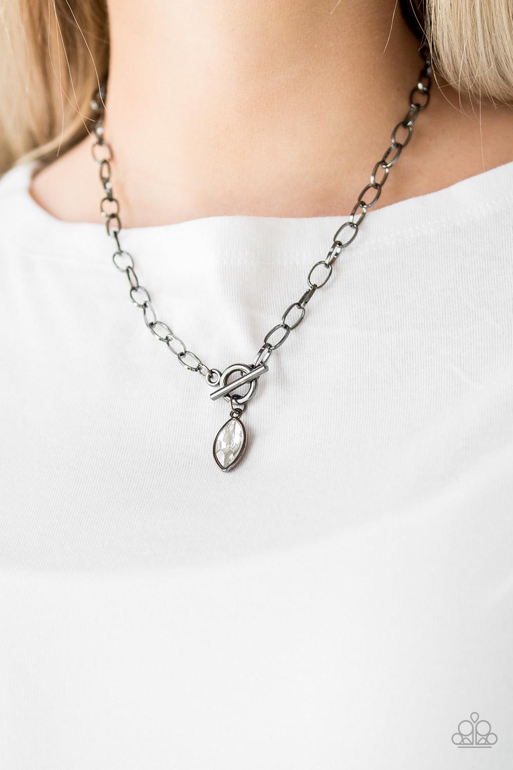 Paparazzi Accessories Club Sparkle - Black Featuring a regal marquise style cut, a glittery white rhinestone swings from the bottom of a gunmetal chain below the collar for a classic look. Features a toggle closure. Sold as one individual necklace. Includ