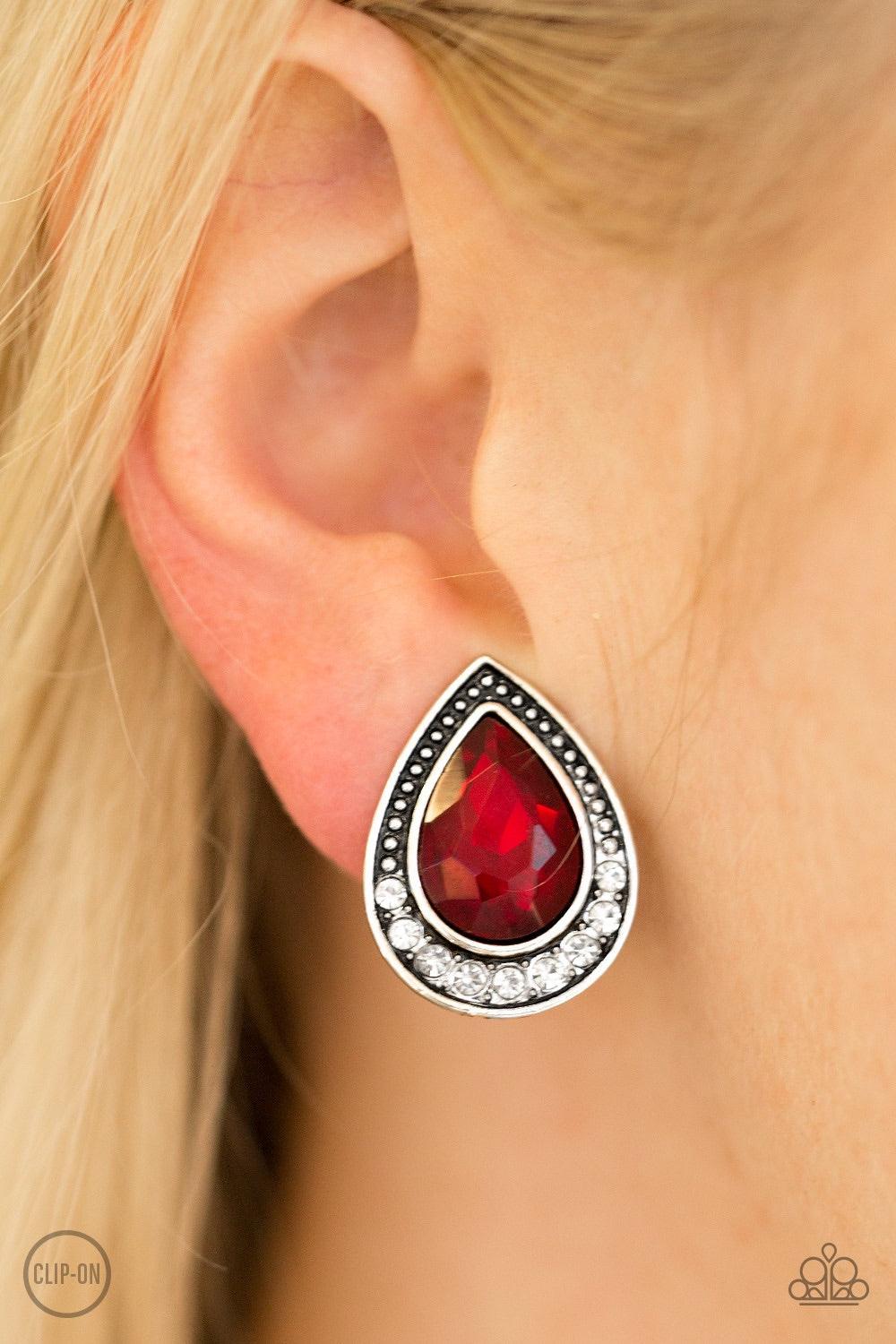 Paparazzi Accessories Radiantly Ravishingly - Red *Clip-On A fiery red gem is pressed into an ornate silver teardrop. Infused with dainty silver studs, the bottom of the frame is encrusted in glittery white rhinestones for a classic finish. Earring attach