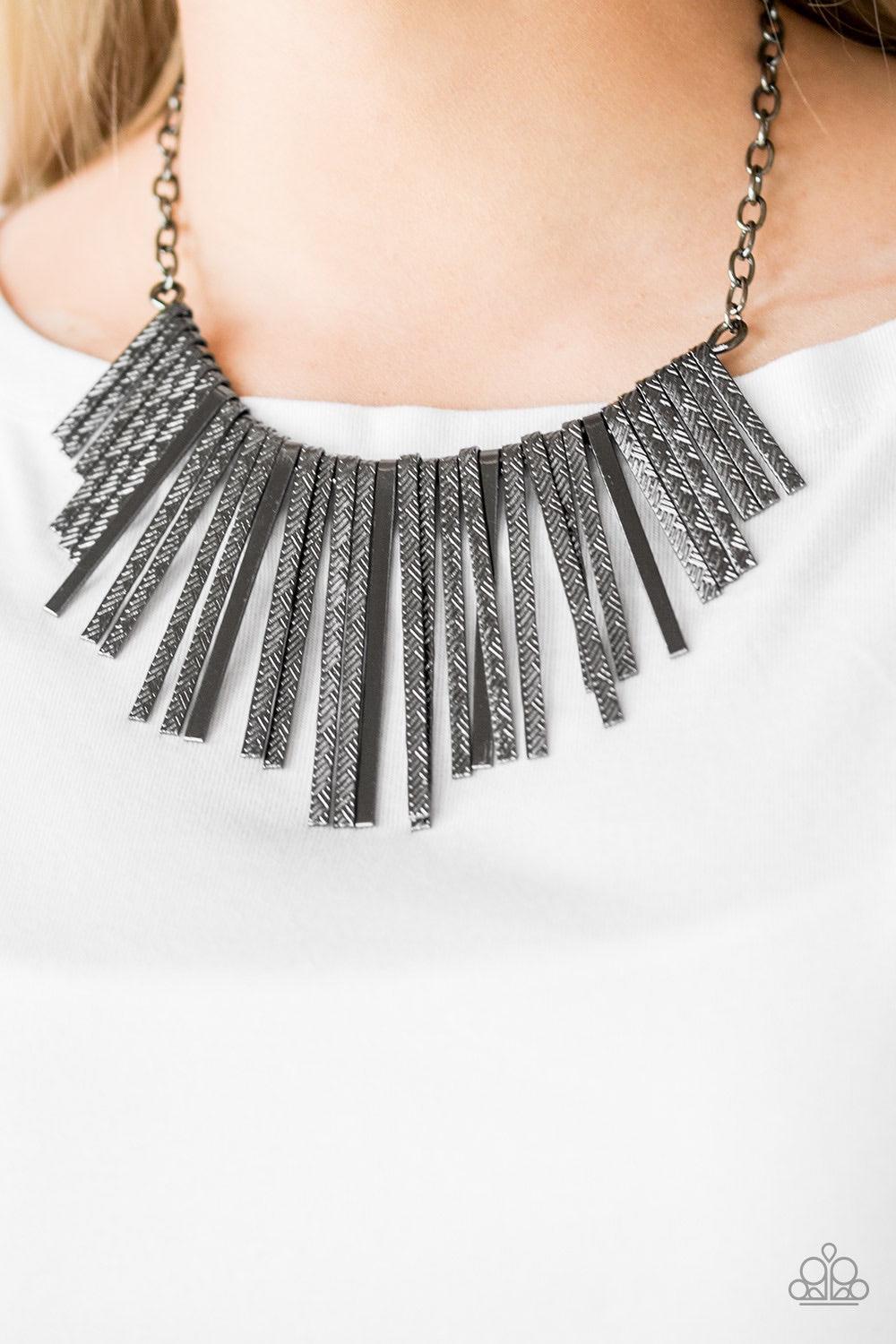 Paparazzi Accessories Welcome To The Pack - Black Embossed in edgy linear patterns, flat gunmetal rods alternate with plain gunmetal rods below the collar, creating a fiercely tapered fringe. Features an adjustable clasp closure. Jewelry