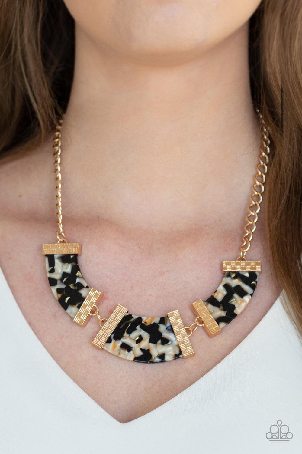 Paparazzi Accessories HAUTE Blooded ~Black A trio of speckled acrylic frames are nestled inside checker textured gold fittings as they link below the collar for a seasonal flair. Features an adjustable clasp closure.