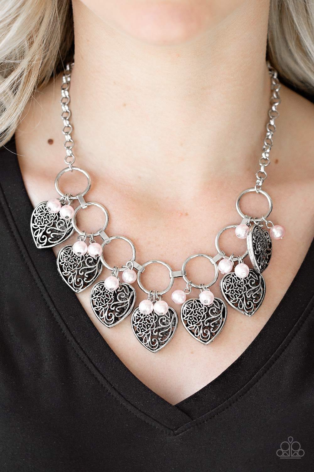 Paparazzi Accessories Very Valentine ~Pink Infused with classic pink pearls, vintage locket-like heart frames swing from the bottoms of bold silver hoops, creating a flirtatious fringe below the collar. Features an adjustable clasp closure. Sold as one in