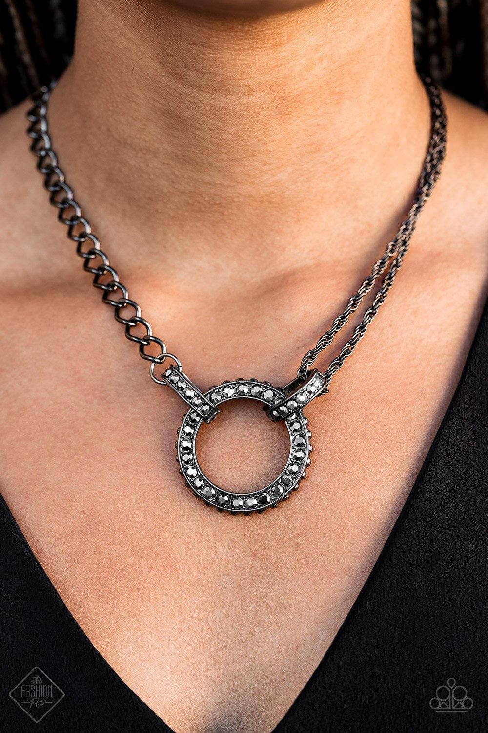 Paparazzi Accessories Razzle Dazzle - Black Featuring mismatched gunmetal black chains, a studded black pendant is encrusted in glittery black rhinestones and hangs below the collar for a dramatic industrial look. Features an adjustable clasp closure. Jew