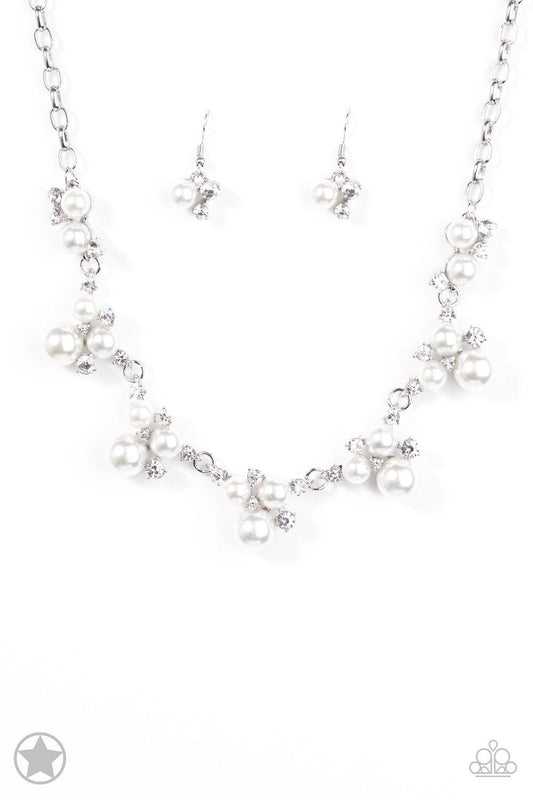 Paparazzi Accessories Toast To Perfection - White Clusters of pearls and dazzling white rhinestones join below the collar, creating refined frames. Infused with a glistening silver chain, the sections of luminescent frames trickle along the neck in a time