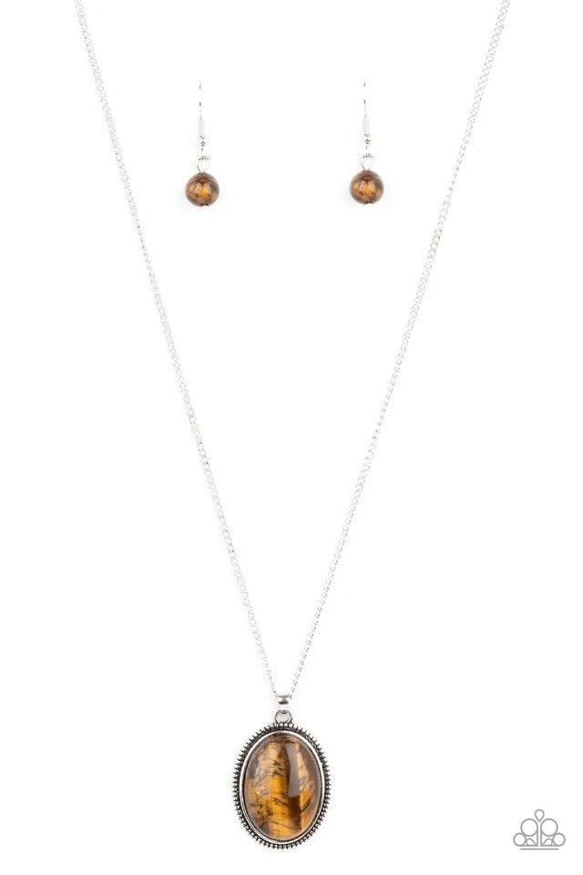 Paparazzi Accessories Tranquil Talisman - Brown An oval tiger's eye stone is pressed into the center of a studded silver frame, creating a tranquil pendant below the collar. Features an adjustable clasp closure. Sold as one individual necklace. Includes o