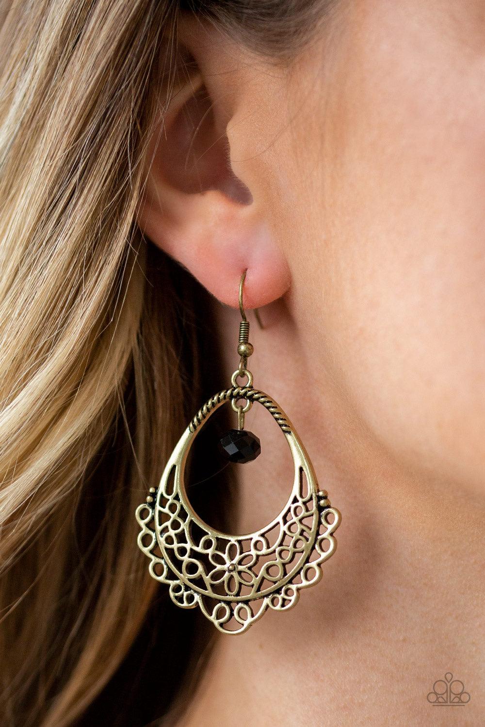 Paparazzi Accessories Garden Society - Brass Glistening brass filigree swirls into a whimsical floral pattern on the bottom of an ornate teardrop frame. A black crystal-like bead swings from the top of the frame for a sparkling finish. Earring attaches to