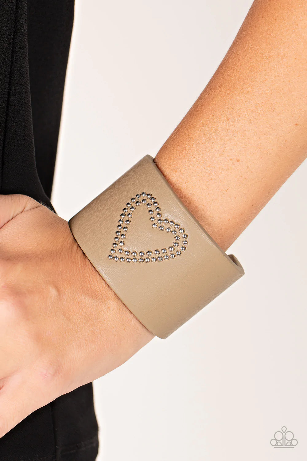 Paparazzi Accessories Rodeo Romance - Brown The center of a brown leather cuff is studded in a charming heart pattern, creating a rustically romantic look around the wrist. Jewelry