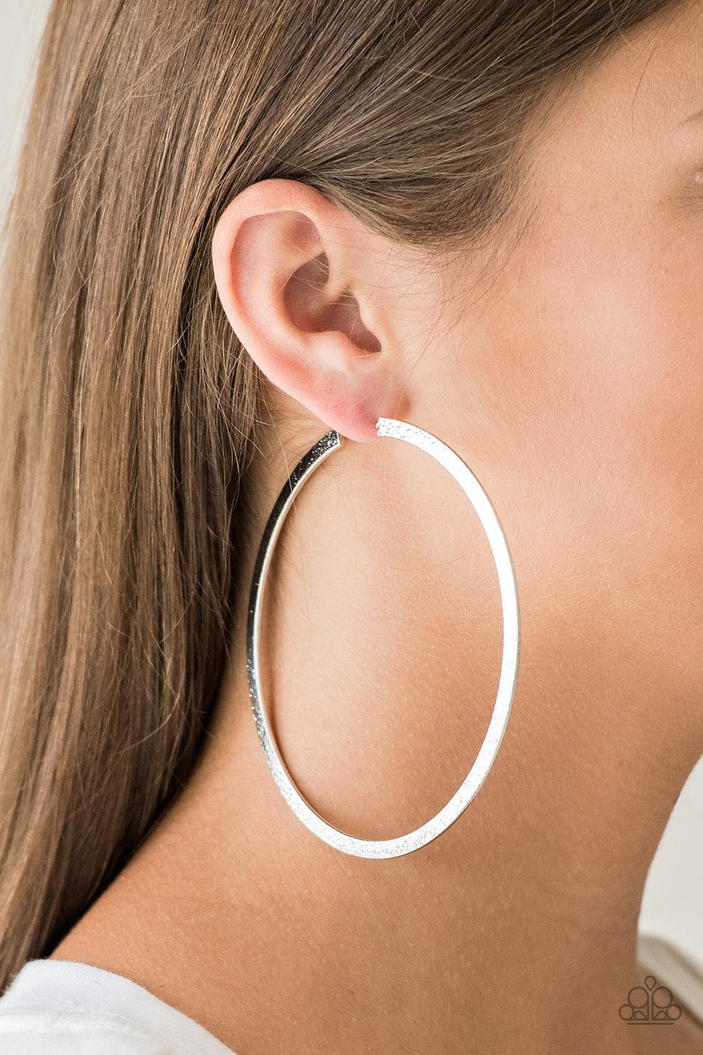 Paparazzi Accessories Size Them Up - Silver One side of a silver hoop is delicately hammered, adding blinding shimmer to the dramatic palette. Hoop measures 3 1/2” in diameter. Earring attaches to a standard post fitting. Sold as one pair of hoop earrings