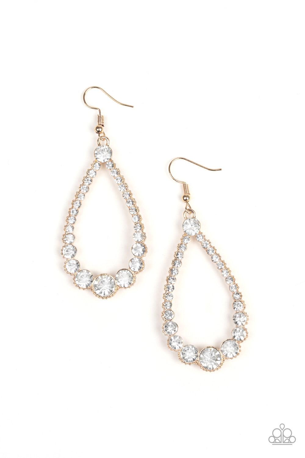 Paparazzi Accessories Token Twinkle - Gold A collection of glassy white rhinestones are encrusted along the front of an ornate gold teardrop. The sparkling rhinestones gradually increase in size at the bottom of the lure for a sophisticated finish. Earrin