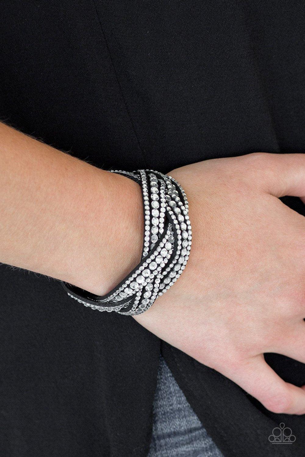 Paparazzi Accessories Bring On The Bling - Black Varying in size, glassy white rhinestones are encrusted along interwoven black suede bands, creating blinding shimmer across the wrist. Features an adjustable snap closure. Sold as one individual bracelet.